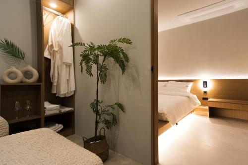 a bedroom with a bed and a mirror and a plant at Yeobaek Hotel in Incheon