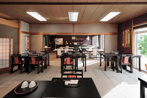a restaurant with black tables and chairs and a dining room at Nankishirahama Hotel Akariya in Shirahama