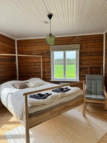 a bedroom with a bed and a window and a chair at Villa Onni in Kauhajoki