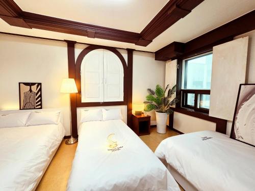 a room with two beds and a window at Thema Stay Hotel in Pyeongtaek