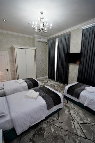 a bedroom with two beds and a chandelier at Next Hotel Samarkand in Samarkand