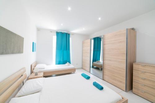 a bedroom with two beds and a mirror at Tonis City Apartments in St Julian's
