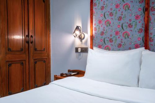 a bedroom with a bed and a wall with a flower pattern at Girisadan Boutique Stay in Jaipur