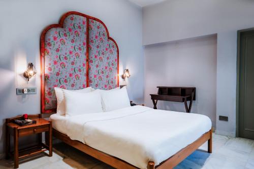 a bedroom with a large bed and a piano at Girisadan Boutique Stay in Jaipur