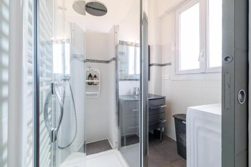 une salle de bain blanche avec une douche et un lavabo dans l'établissement GRAND PALAIS - Beautiful top floor studio - Sea front with AC, à Vallauris