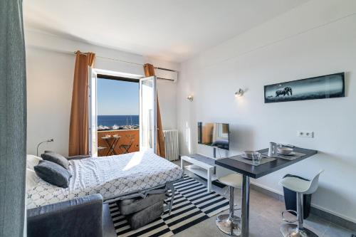 une chambre avec un lit, un bureau et une fenêtre dans l'établissement GRAND PALAIS - Beautiful top floor studio - Sea front with AC, à Vallauris