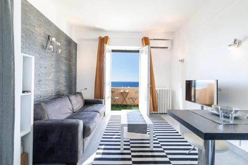 un salon avec un canapé et une table dans l'établissement GRAND PALAIS - Beautiful top floor studio - Sea front with AC, à Vallauris