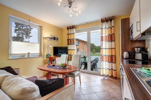 a living room with a couch and a table and a kitchen at Wohnung 4 Am Sportplatz &Uuml;ckeritz in Ueckeritz
