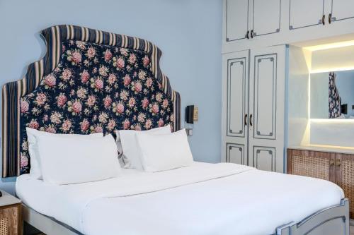 a bedroom with a white bed with a floral headboard at Girisadan Boutique Stay in Jaipur