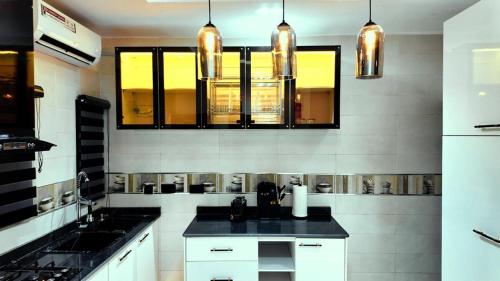 a kitchen with white cabinets and a black counter top at Redbox Luxury Apartments in Port Harcourt