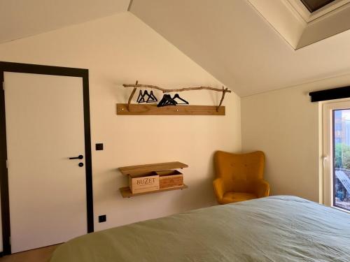 a bedroom with a bed and a chair and a window at STH1 - Cachette en centre-ville in Saint-Hubert