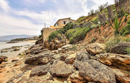 a house on the side of a rocky beach at Amazing Apartment In Trappeto With Wifi in Trappeto