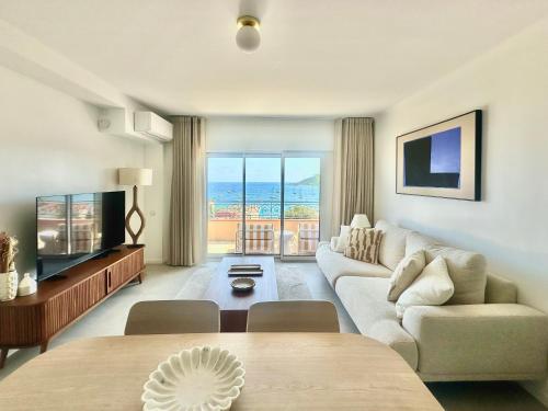 Una sala de estar con un sofá y un televisor. en Exceptional - Sea View - 6 People - Air Conditioning - Parking, en Saint-Raphaël