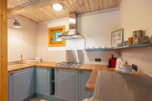 a kitchen with blue cabinets and a stove top oven at Nomád Glamping in Noszvaj