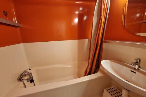 a small bathroom with a tub and a sink at Beautiful studio with balcony - nice view in Bourg-Saint-Maurice