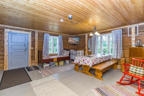 a room with a table and a bench in a cabin at Savupirtti 1819 in Pudasjärvi
