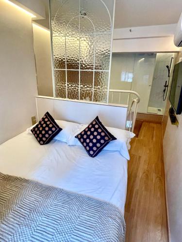 a bed with black and white pillows on it at 上海璞逸酒店-豫园 新天地 老西门地铁站店 in Shanghai