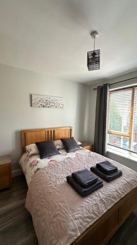 a bedroom with a bed with two black towels on it at Bright Spacious Apartment in Dublin
