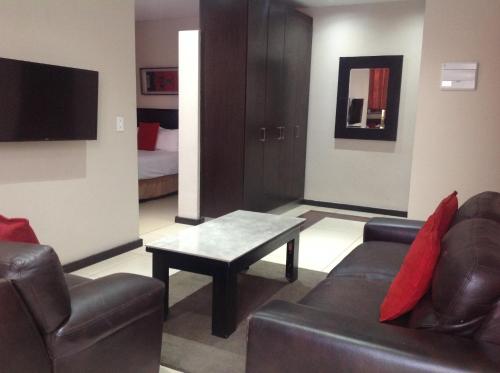 a living room with a couch and a coffee table at Alcazaba Hotel in Johannesburg