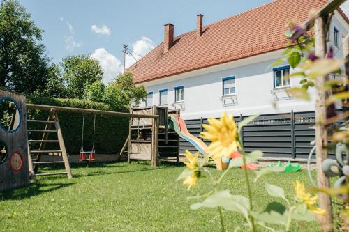 a playground in a yard next to a house at Schmiedbauerhof in Sankt Margarethen im Lavanttal