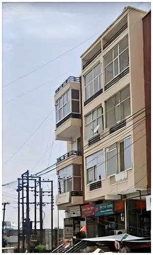 a tall building with balconies on a city street at Hotel Radha Palace ! Just beside ISCKON temple and Close to Prem mandir ! Fully Air Conditioned Family rooms with Lift and Parking Availability in Vrindāvan