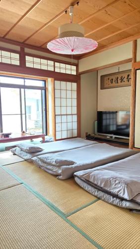 a large room with two beds and a fan at 海の風 in Wakayama