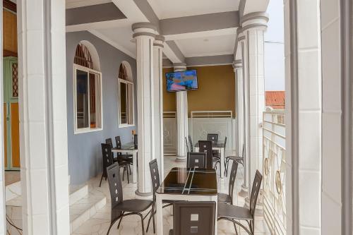 a dining room with tables and chairs and a tv at Korogwe Comfort Hotel in Nkunjila