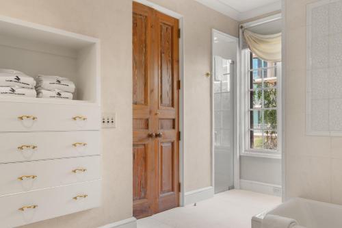 オレンジビーチにあるVilla Grandeの白いドレッサーと木製のドアのあるバスルーム