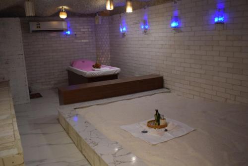a bathroom with a tub and a sink with a bottle of wine at Golden Tulip Nizwa Hotel in Nizwa