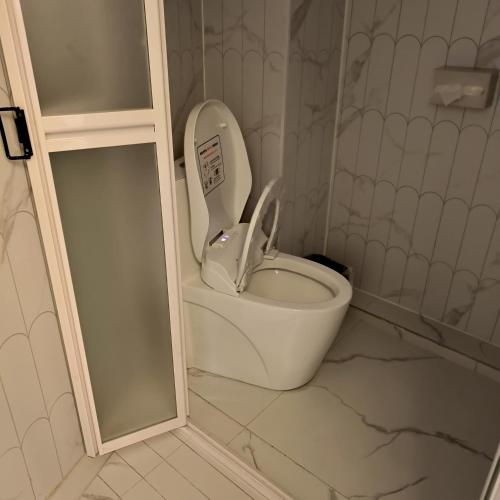 a white toilet with the seat up in a bathroom at 上海璞逸酒店-豫园 新天地 老西门地铁站店 in Shanghai
