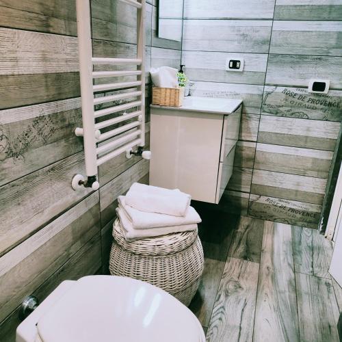 a bathroom with a toilet and a sink and towels at Casale dei Villa villa with pool and private parking in Ciampino