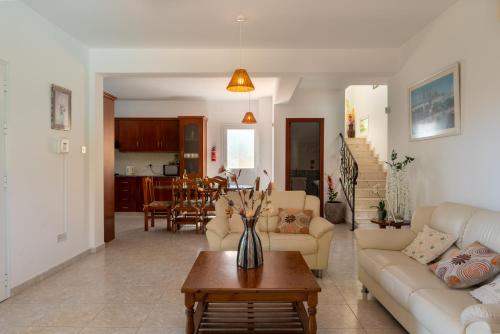 a living room with a couch and a table at Peyia Villas Cyprus in Peyia