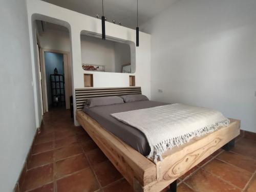 a bedroom with a large bed with a wooden frame at La Bellamar - Apartamento en primera línea mar- in Premiá de Mar