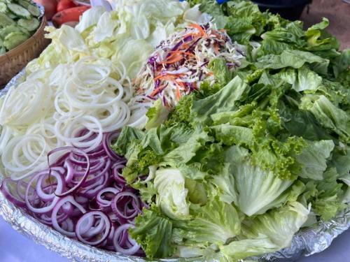 a plate of lettuce and onions on a table at Haad Yao Bayview Resort in Haad Yao