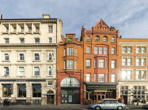 a group of buildings on a city street with a car at Comfortable flat in a very historic part of London in London
