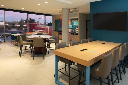 a conference room with tables and chairs and a flat screen tv at avid hotel Guadalajara Aeropuerto Norte in Guadalajara