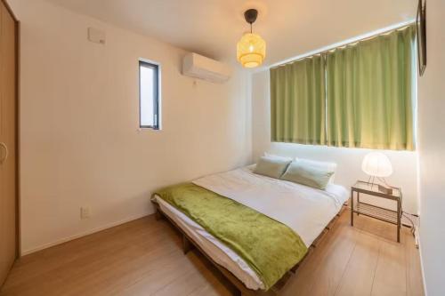 a bedroom with a bed with a green blanket at Skytree View! Modern Entire House in Tokyo in Tokyo