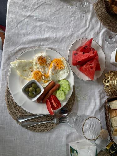 DzhangyarykにあるNomad place - horse riding tour Son-Kulのテーブルの上に朝食の皿が2枚