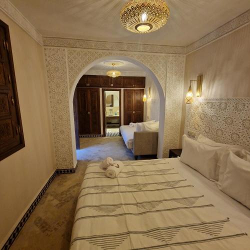 a bedroom with a bed with a teddy bear on it at Riad Noon in Marrakesh