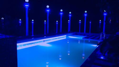 a swimming pool with blue lights in the dark at AppleLand City Athirapilly by Hotels Cart in Athirappally