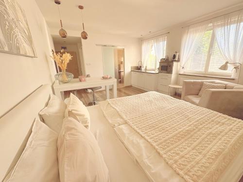a white bedroom with a bed and a living room at Trio Apartments in Ostrava