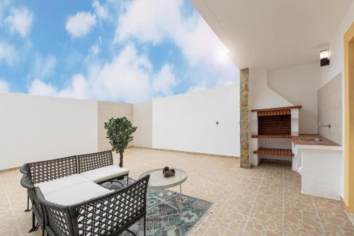 a patio with a table and chairs and a fireplace at Papoa Beach House in Peniche