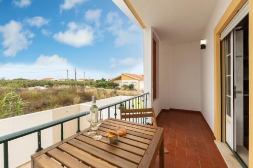 a balcony with a table and a view of the ocean at Papoa Beach House in Peniche