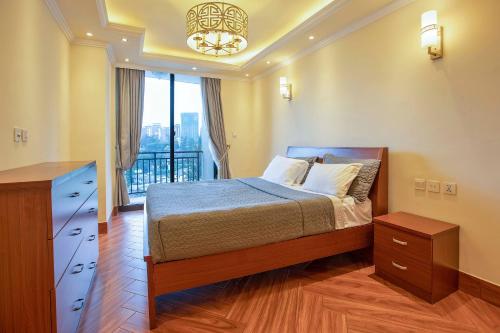 sypialnia z łóżkiem i balkonem z żyrandolem w obiekcie The YALE Place w Addis Abebie