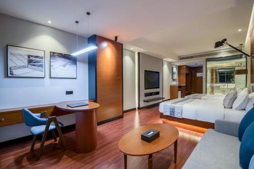 a hotel room with a bed and a couch at Xishuangbanna Jinghong Wanji Lijing Hotel in Jinghong