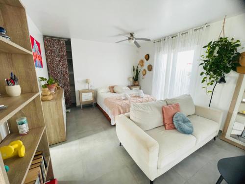 a living room with a couch and a bed at Calpe bungalow adosado piscina jardin barbacoa aire centrico moderno in Calpe