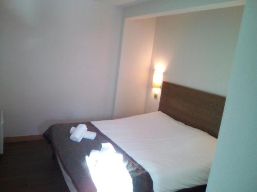 a bedroom with a bed with a white object on it at apartment for 6 people in Béranger