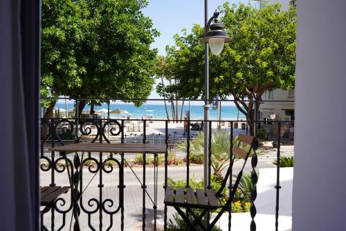a balcony with a table and benches and the beach at Casa Diez in Estepona