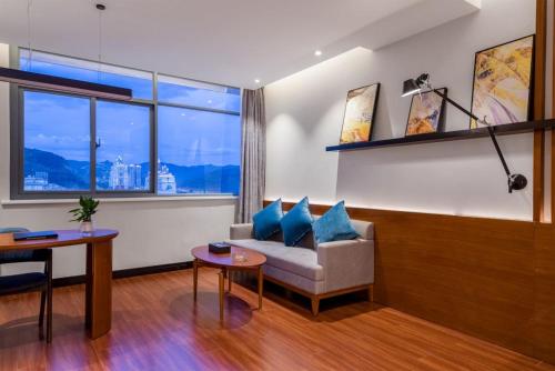 a living room with a couch and a table at Xishuangbanna Jinghong Wanji Lijing Hotel in Jinghong
