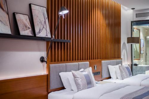 a room with three beds and a lamp at Xishuangbanna Jinghong Wanji Lijing Hotel in Jinghong